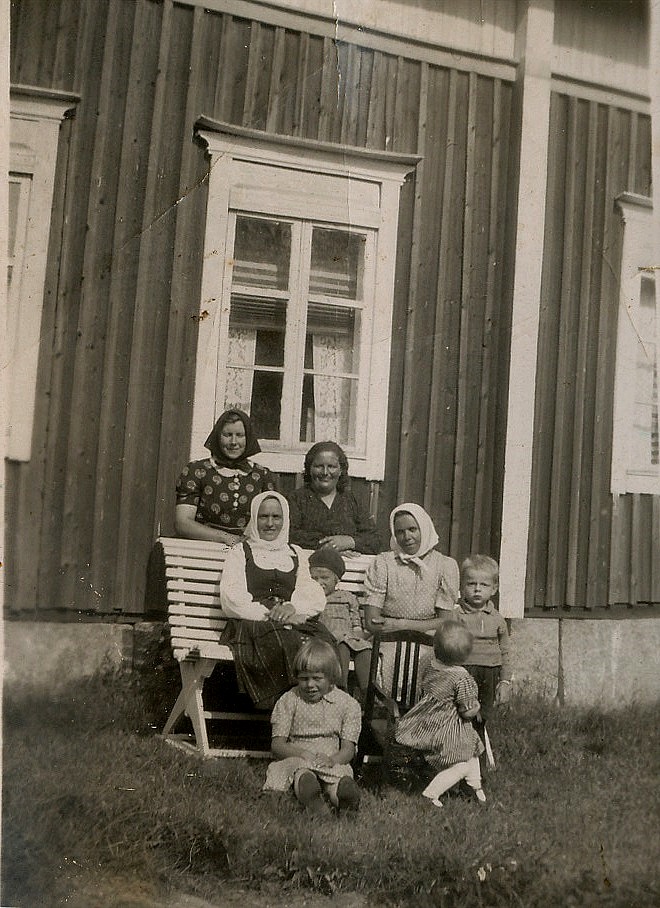 Bakom bänken står Signe Nyström och Hulda Norrgård, på bänken sitter Hulda Lindell och Jenny Lindell. Längst till höger står Alf Norrgård, sittande fram Göta Lindell.