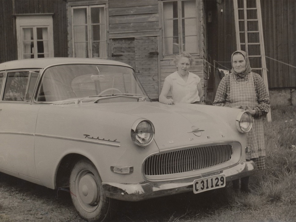 Aina Norén (1913-1999) gift med Eino Veikkolainen, som var född i Karelen men som bodde i Lerviken i Kristinestad efter evakueringen. De var barnlösa och bosatta i Bålsta i Sverige och här är de i Dagsmark och visar upp sin nya Opel Rekord. På fotot Aina tillsammans med sin mor ”Bodas-Fina” eller ”Central-Fina”. 