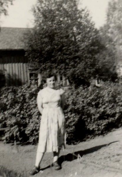 På fotot Anita Björklund framför den gamla bondgården.
