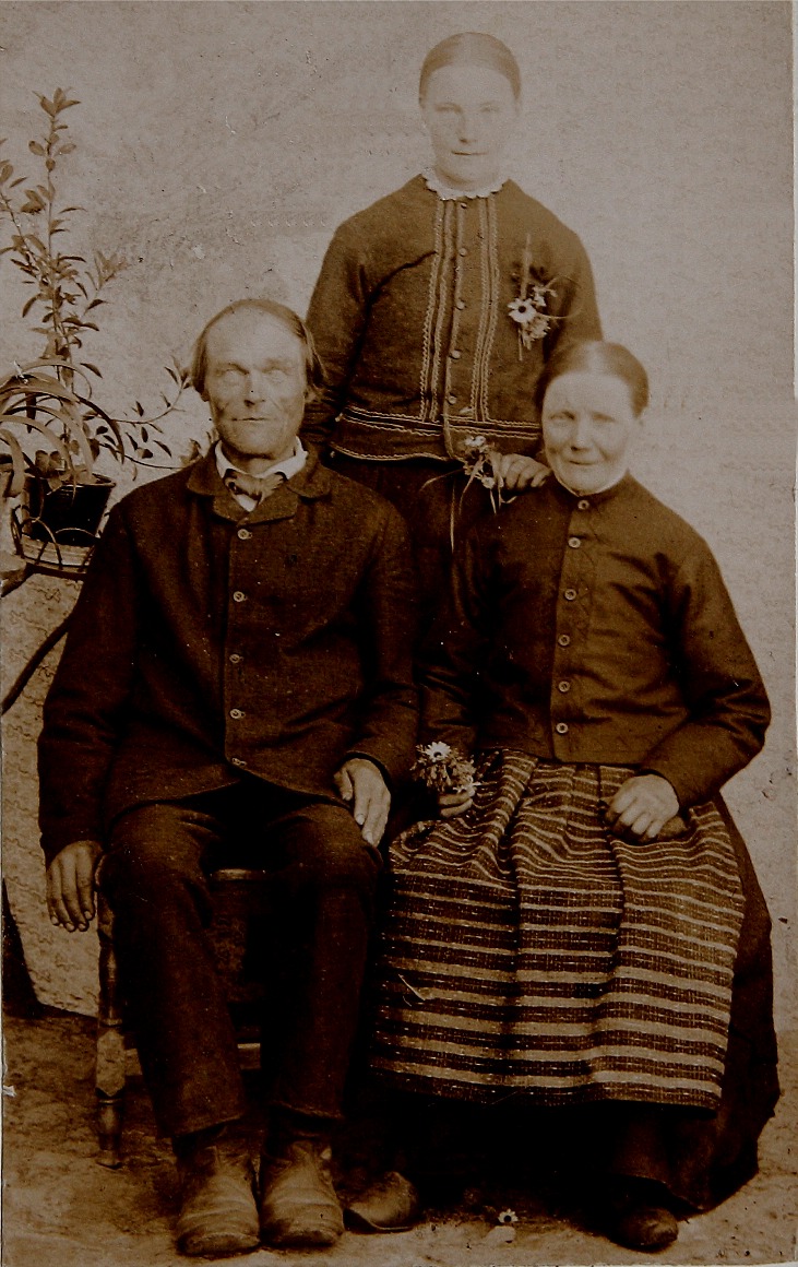 På bilden sitter Johan Prunnila och Anna Greta och bakom står dottern Maria Wilhelmina, alltså ”Kionas-Mina” som sedan gifte sig med Ivar Söderholm. Följaktligen kallades han för Kionas-Ivar och han har fått en väg uppkallad efter sig på Bergåsen.