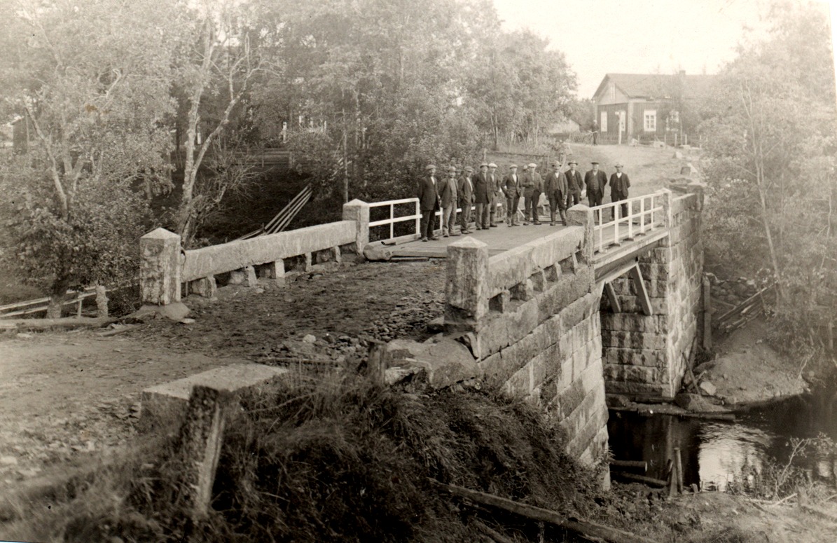 På den här bilden ser vi att lillstugan flyttats över vägen, där den fortfarande står. Detta foto är från början på 1930-talet då en grupp stenhuggare från Vanhakylä byggde den nya Lillbron. 