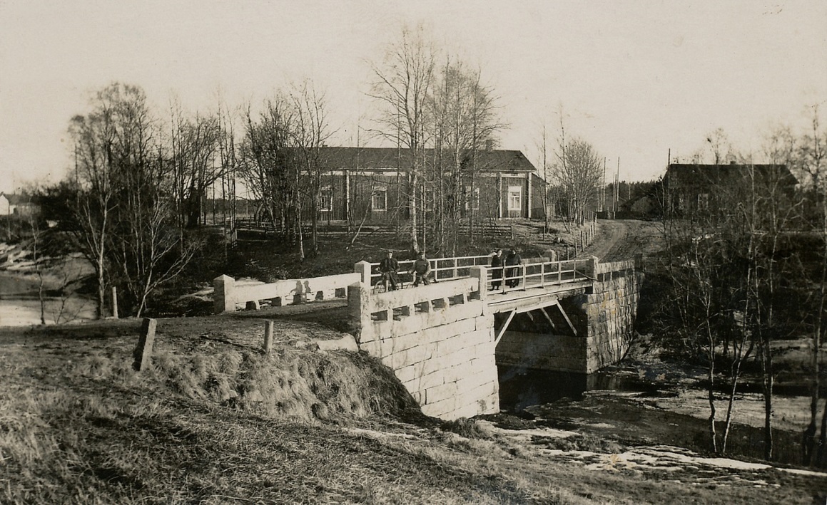 På denna bild från 1930-talet ser vi den nya stenbron över Lillån och bakgrunden syns den stora bondgården bra. Här ser vi också att sytningsstugan flyttats över vägen till den plats där den fortfarande står. 