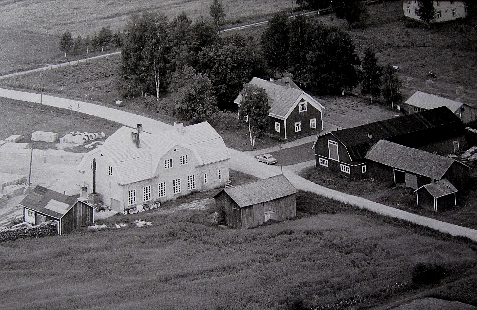 På flygfotot från år 1961 så ser vi att det är tillverkning av tellblock som gäller på det nedlagda mejeriet. Långfors gård med uthus syns till höger. 