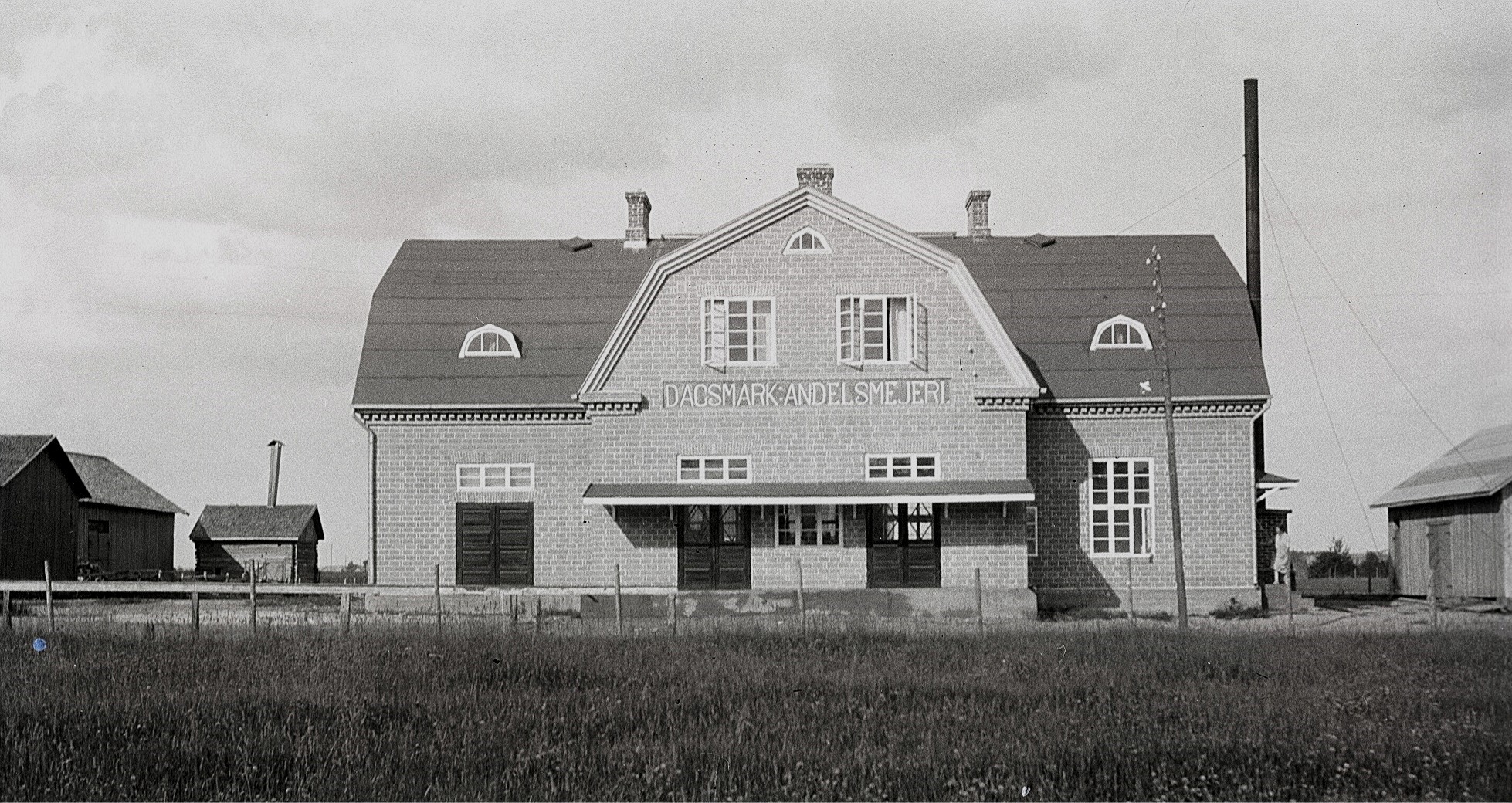 Läraren Selim Björses var en aktiv fotograf, som ofta rörde sig i byarna. Detta foto av det nybyggda mejeriet är från början av 1930-talet och till vänster syns uthusen hos Erland Krook.