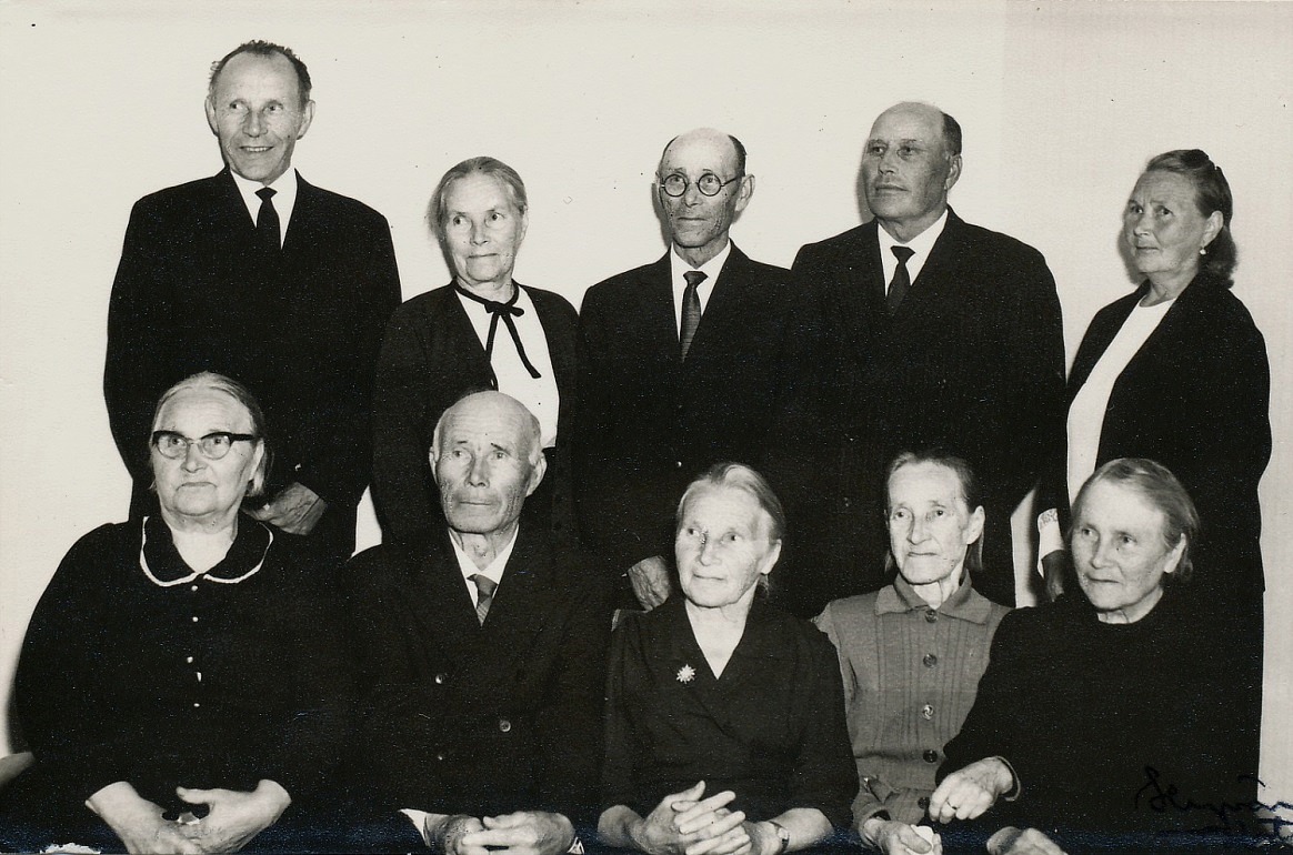 På bilden Alma och alla hennes syskon, utom Anna Sofia, f. 1886 som emigrerade till Amerika. Fotot från år 1967. Nere t.v. Alvina (1889-1982)som gifte sig med Erland Rosenback, följande Johannes (1891-1970) som gifte sig med Hilma Elvira Ojanperä från Storå och som tog namnet Hällback, Maria Vilhelmina (1893-1989) som gifte sig med Sigfrid Storlåhls från Måston eller Lillsund, följande Alma (1895-1984) som gifte sig med Emil Nyberg och längst ut Amanda (1897-1985) som gifte sig med Evert Gröndahl. Stående fr.v. Viktor (1899-1981) som först varit gift med Helmi Tuominiemi men som sedan gifte sig med Selma Nyberg och som tog namnet Berglind, följande är Jenny (1901-1976) som var ogift, följande Leander (1904-1972) som gifte sig med Selma Hammarberg, sedan Arthur (1905-1985) som gifte sig med Helmi Lydia Jansson från Storå och längst t.h. Mathilda (1908-1984) som gifte sig med Emil Lillsjö. 