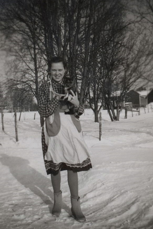 Här Ulla-Ellen Ånäs med sin katt. I bakgrunden syn Karl Lillkulls lillstuga.