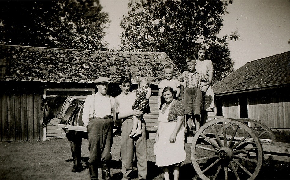 Här står Egil Mannfolk med dottern Mayvor i famnen. Till vänster står hans far Erland Mannfolk (1895-1972) och mitt i bild hans mor Elsa (f. i Sideby 1897-1982). Pojken bakom Elsa torde vara Tage Mannfolk.