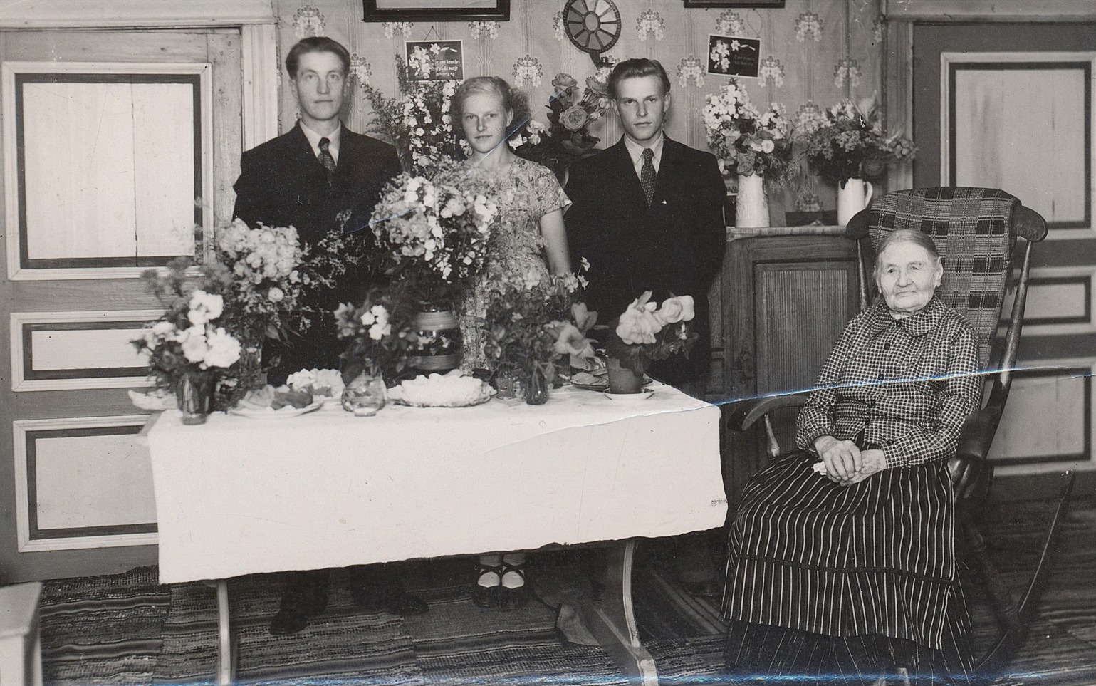 I gungstolen sitter Karolina på sin 100-årsdag år 1951. Mannen till vänster är Uno Äbb och i mitten står Ruth och Alf Mitts.