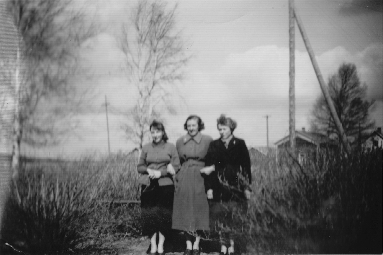 Bakom bärbuskarna på Brobackan skymtar Minas och Anakajsas gården. Flickorna på bilden är Birgit Lund, Alice Björklund och Marita Lindell. 