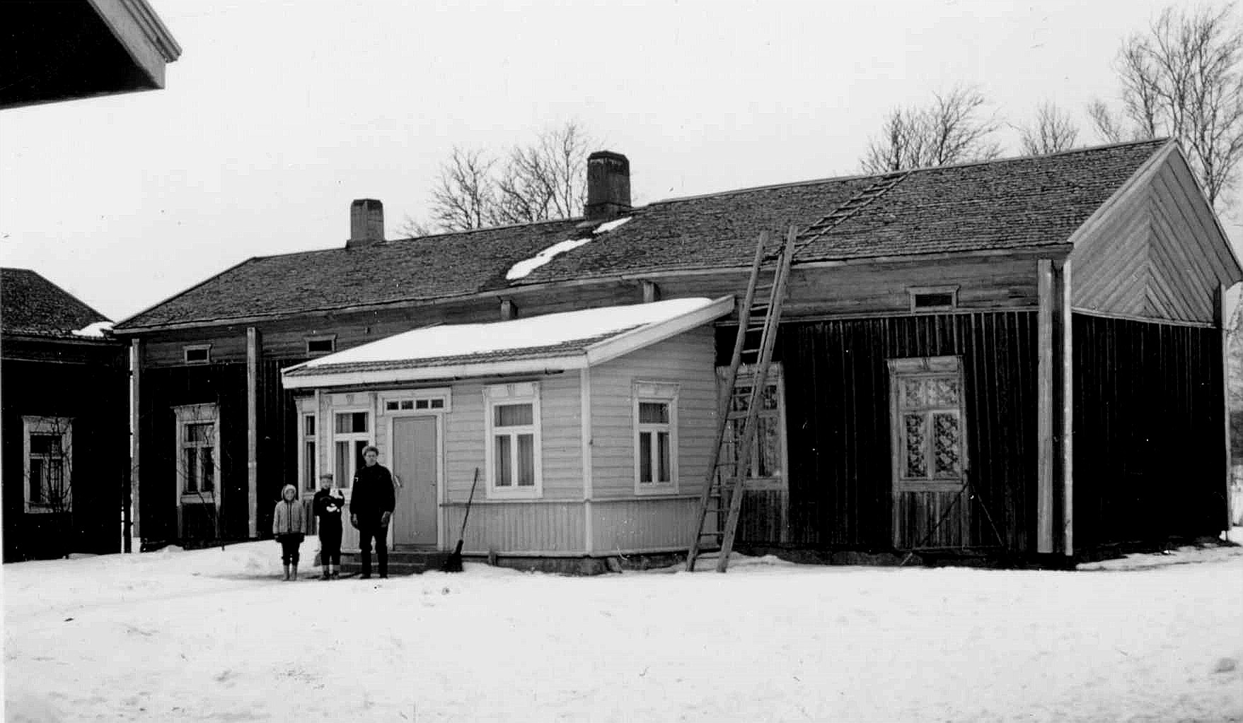 På bilden från 1950-talet står dåvarande ägaren Karl Lillkull med barnen Bernice och Gösta på gården. Kolla hur nära varandra lillstugan och huvudbyggnaden stod. Små barn rymdes emellan medan de vuxna fick gå runt gården för att komma till baksidan. Fotot taget från öster. 