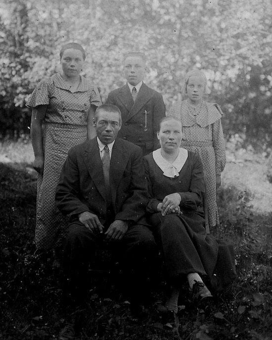 Här sitter Erland Storkull tillsammans med sin andra hustru Martha och bakom står barnen Elin, Arvo och Impi.
