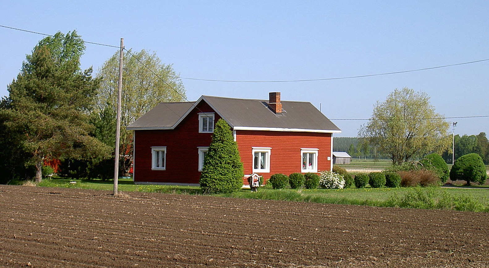 Klemets Nils och Helvis gård fotograferad 2003 från landsvägen, alltså från söder.