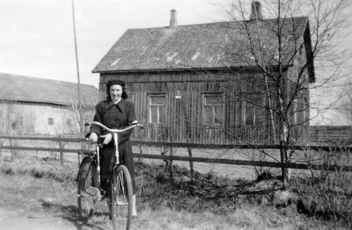 Här på bilden står Frida Klemets med sin cykel framför Frans Storkulls gård på Åbackvägen, där hon arbetade som piga. 