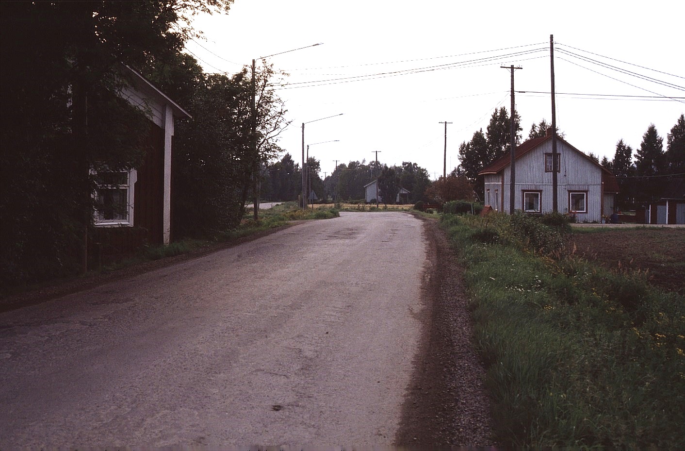 Landsvägen utanför "Mattas-Lennatas" eller "Andersas" som det hette förr. T.h. Artur Lövholms gård och mitt i bild syns Kangas Velis hus. Foto 1983.