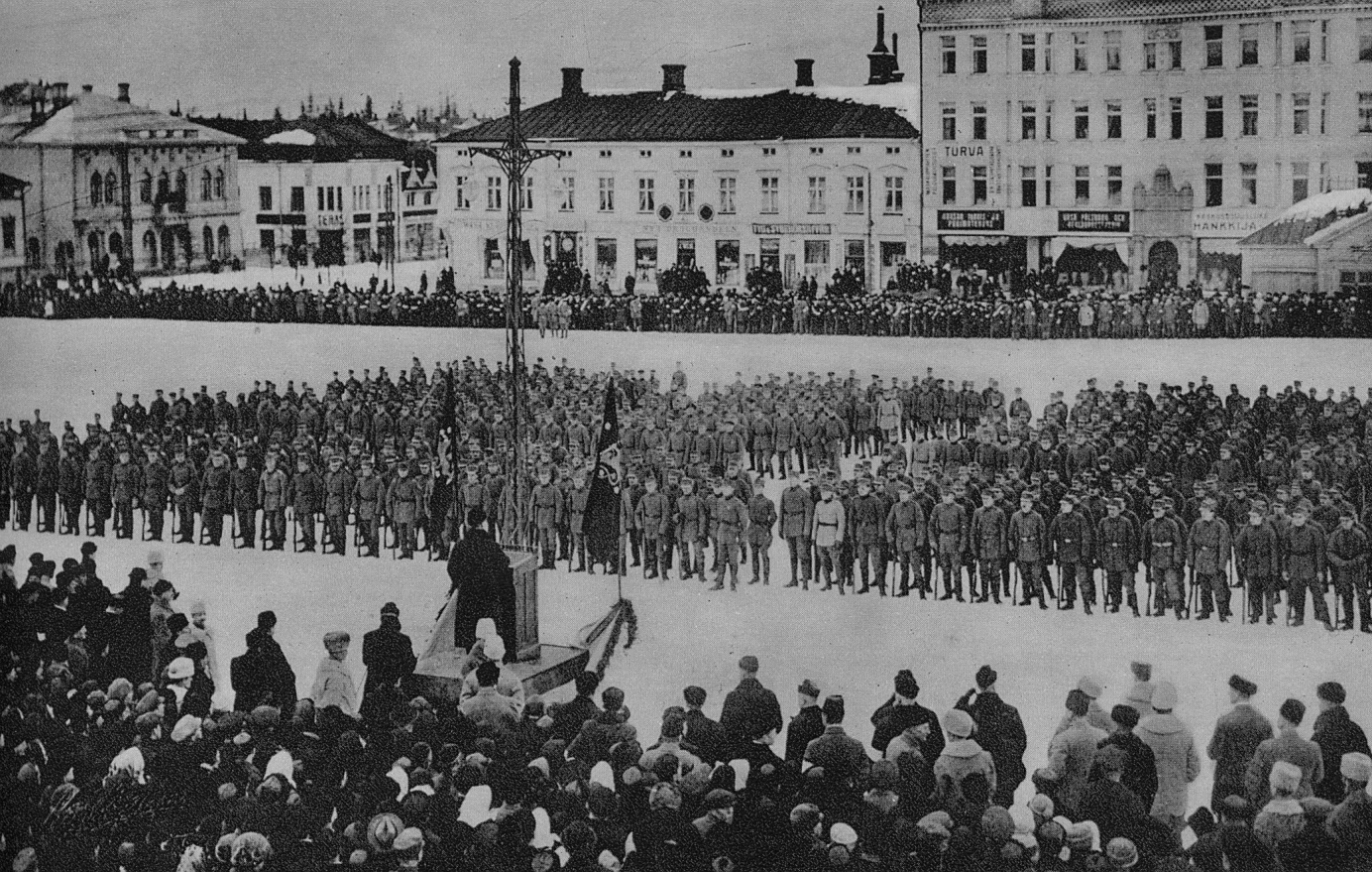 Här står jägarna på torget i Vasa den 25 februari 1918. Efter en lång färd med S/S Arcturus står de och lyssnar på senator Renvall.