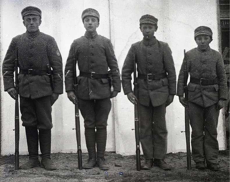 Fyra skyddskårssoldater uppställda hos fotografen Viktor Nylund. Längst till vänster står Artur Rosengren. SLS:s arkiv.