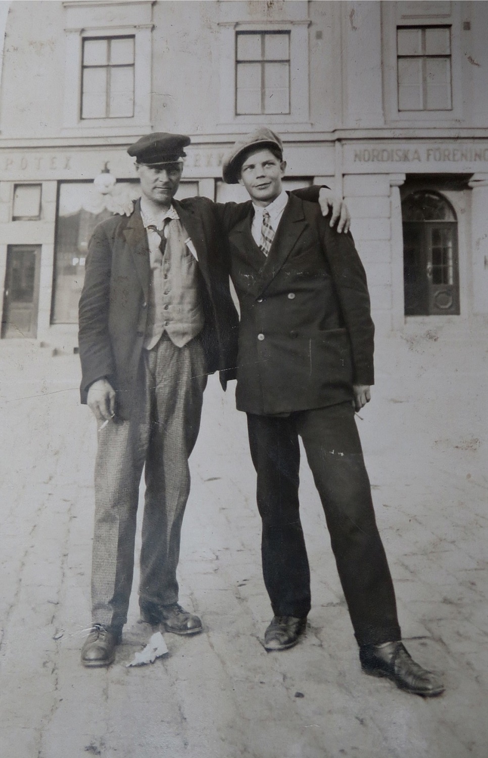 Till vänster står Emil Sved utanför Nordiska Föreningsbankens kontor på Nedre torget i Vasa någon gång på 30-talet. Mannen till höger är tillsvidare okänd.