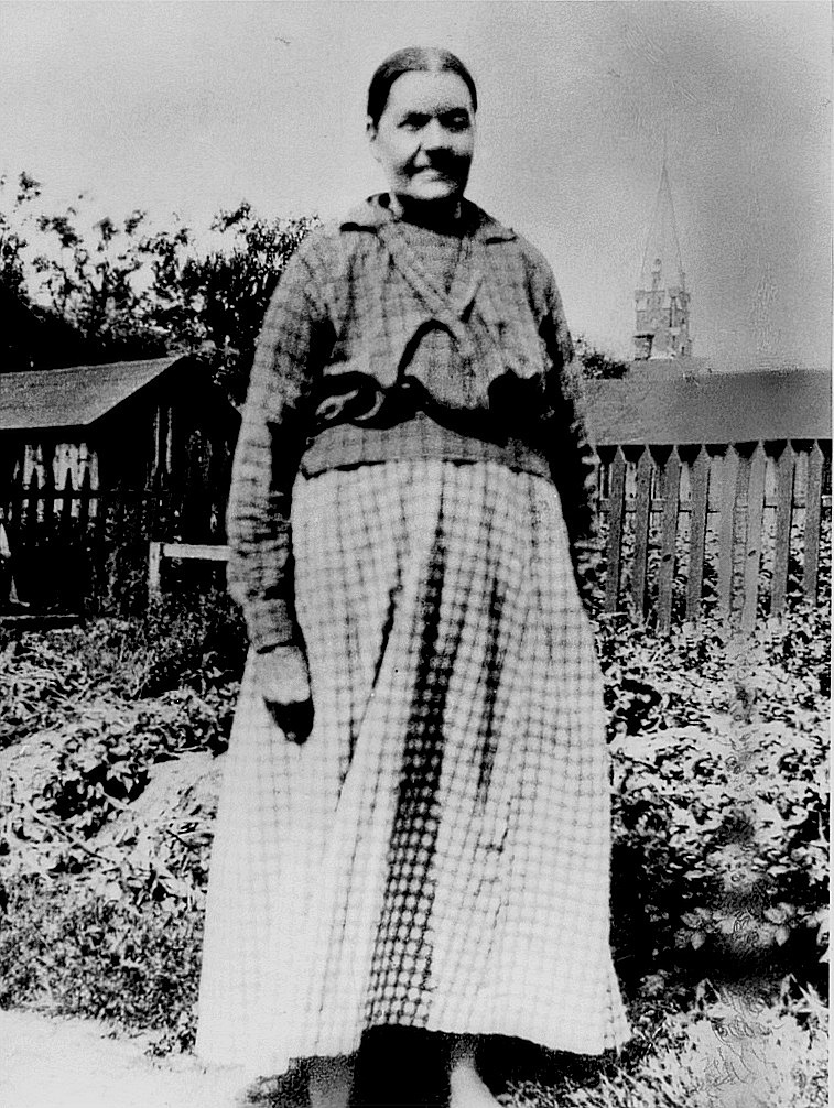 Här står Anna Kajsa Rosenback på gårdsplanen i Kristinestad. I bakgrunden skymtar Kristinestads nya kyrka. Före hon dog, bodde hon en tid i Palon i Dagsmark hos dottern Hulda Granlund.