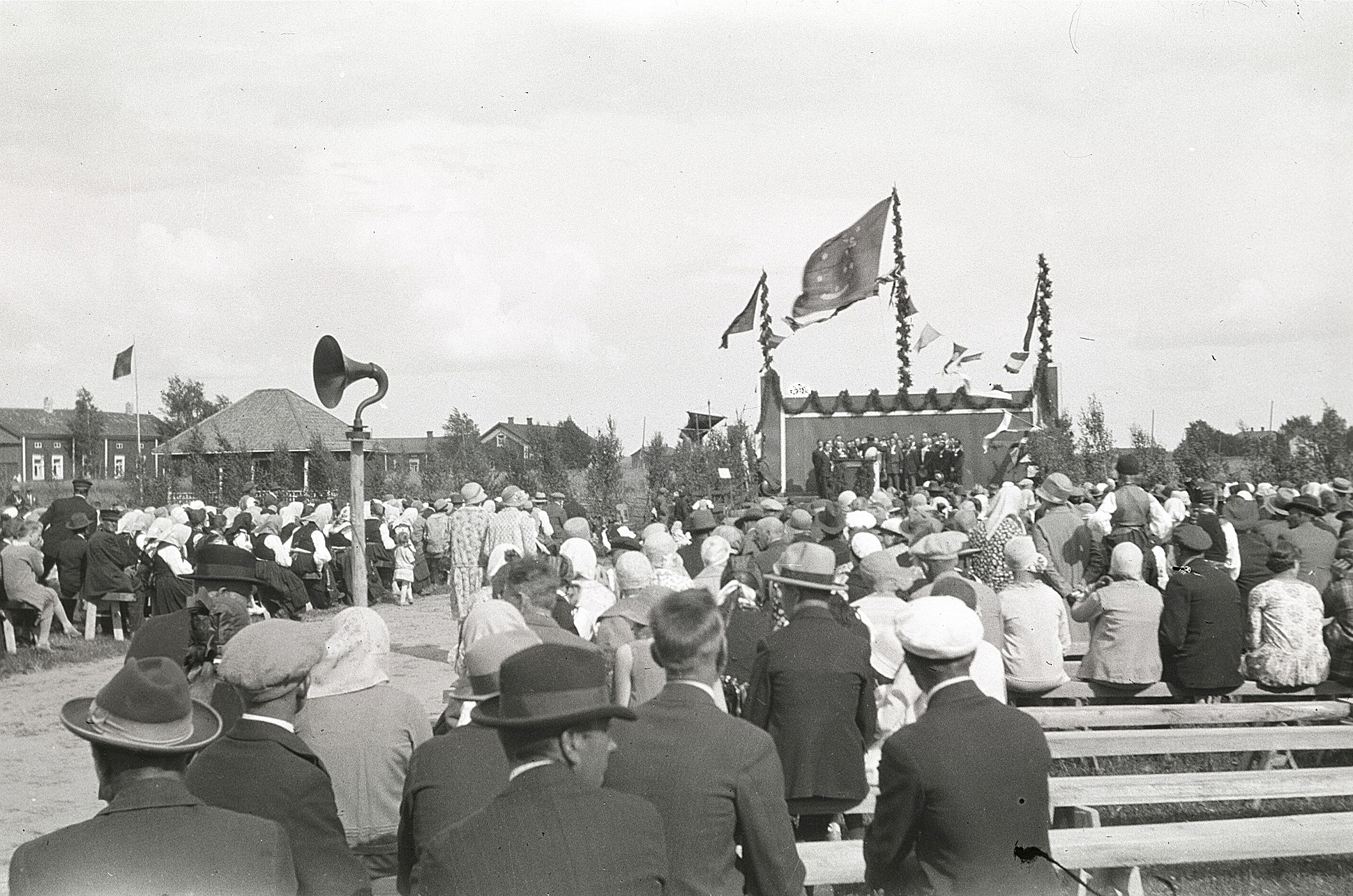 Publiken samlad för att lyssna på körsång på idrottsplanen i Lappfjärd år 1930. Notera speciellt högtalaren.