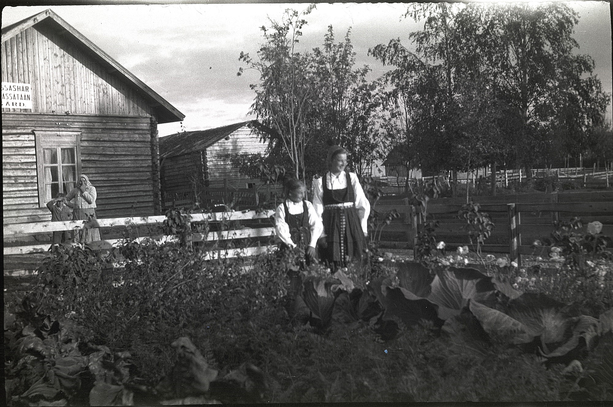 Här systrarna Astrid Nygård, gift Ingves och Anni Nygård, gift Klemets i sitt klubbland. Möjligtvis är det broder Thure med mamma Maria som stå bakom planket. På skylten på väggen står det: "Tyger pressas här".
