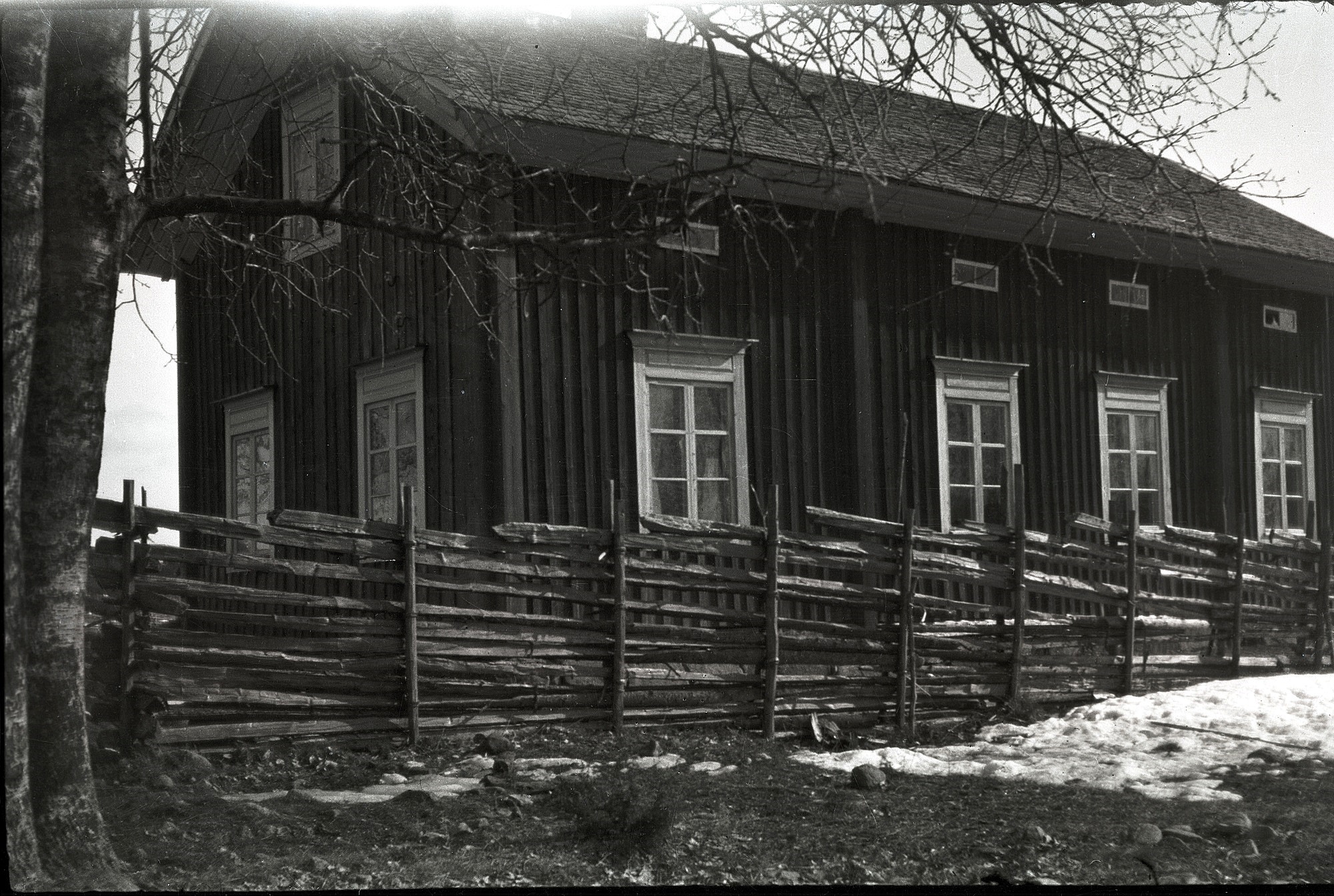 Småbarnskolan på Kladdbackan fram till år 1933. Lärarinnans bostad till vänster och själva skolsalen till höger. Här ett bra exempel på en riktig gärdesgård eller "jeisgål" som den kallades på dialekt. Först slog man ner "stevoran" och så radade man i "trodorna" som sedan bands fast med "stölingan" som var små kluvna granstammar.