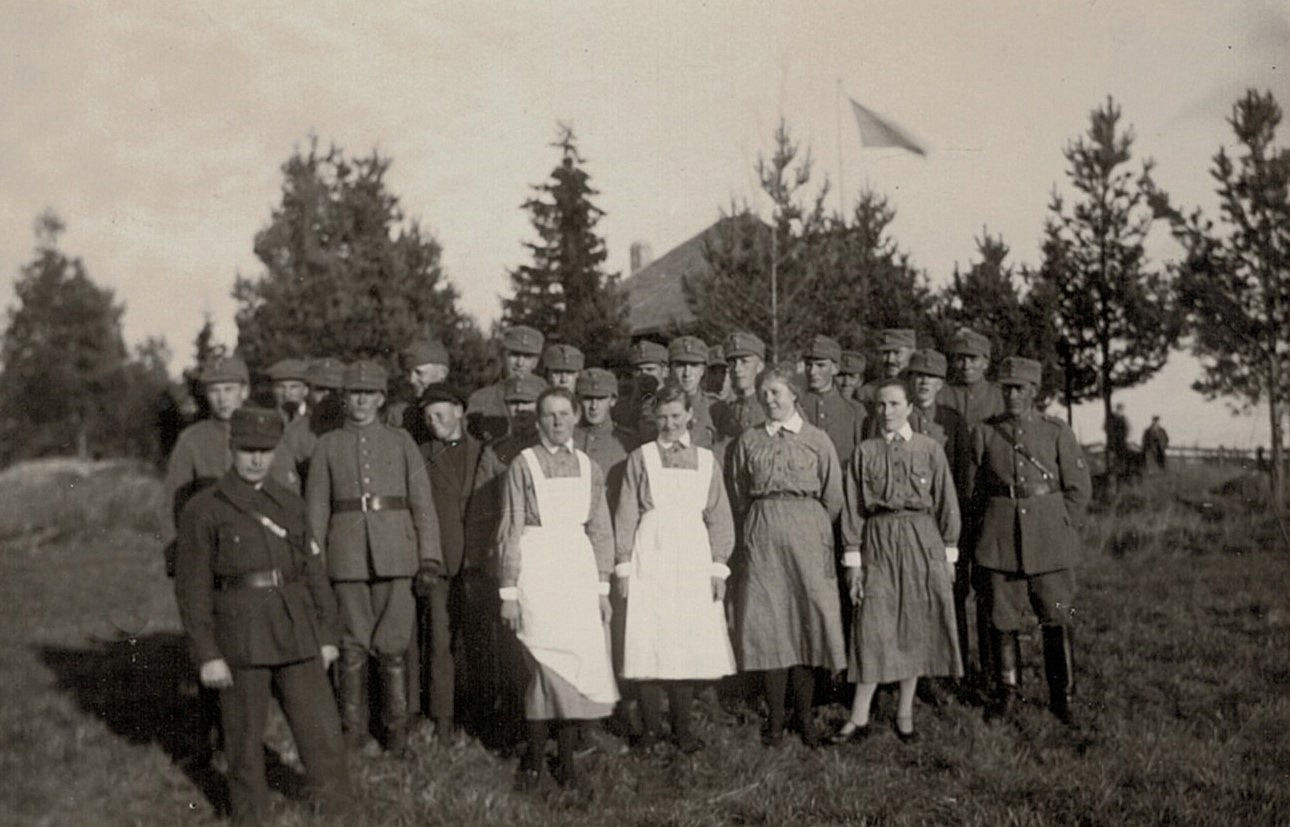 Fotot från 14 oktober 1928 med lottor och skyddskårister framför skjutpaviljongen på skjutplan vid Lillån ovanför mejeriet.