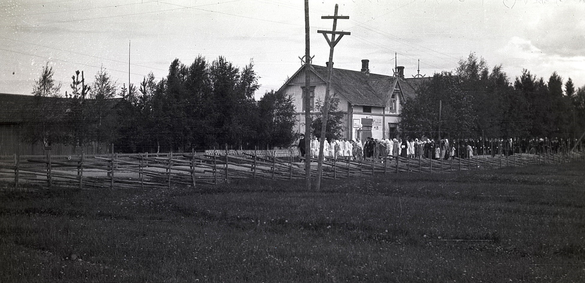 På fotot från midsommaren 1928 ser vi den långa raden av konfirmander, som startar "tenn fö Kaljohanas", alltså vid Charles Ulfves affär nere i kyrkbacken. Längs landsvägen syns en tidstypisk gärdesgård.