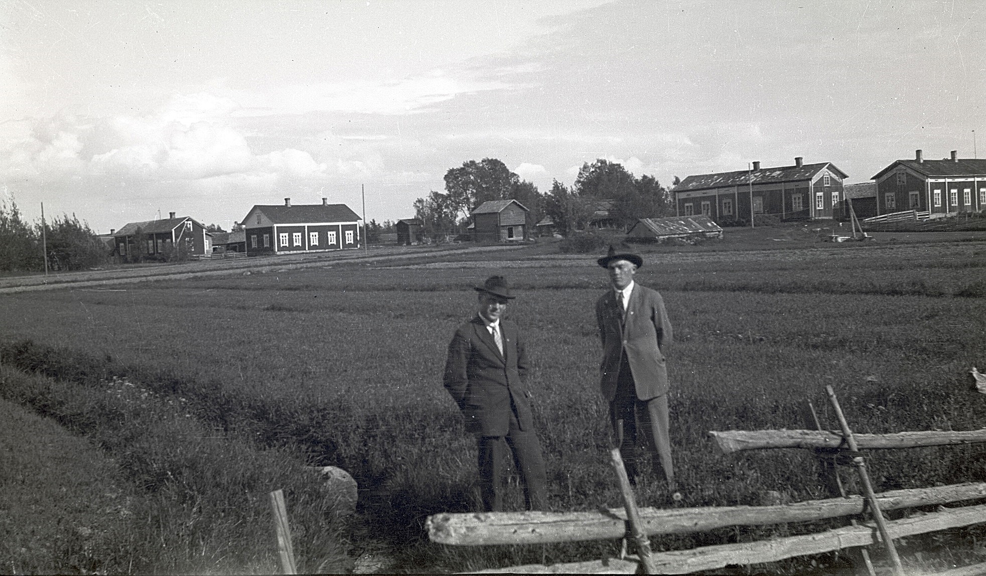 Till vänster Selim Björknäs tillsammans med Frans Bergkulla och i bakgrunden ser vi de ståtliga Bergkulla-gårdarna. Samtliga gårdar är rivna utom den som står längst till vänster.