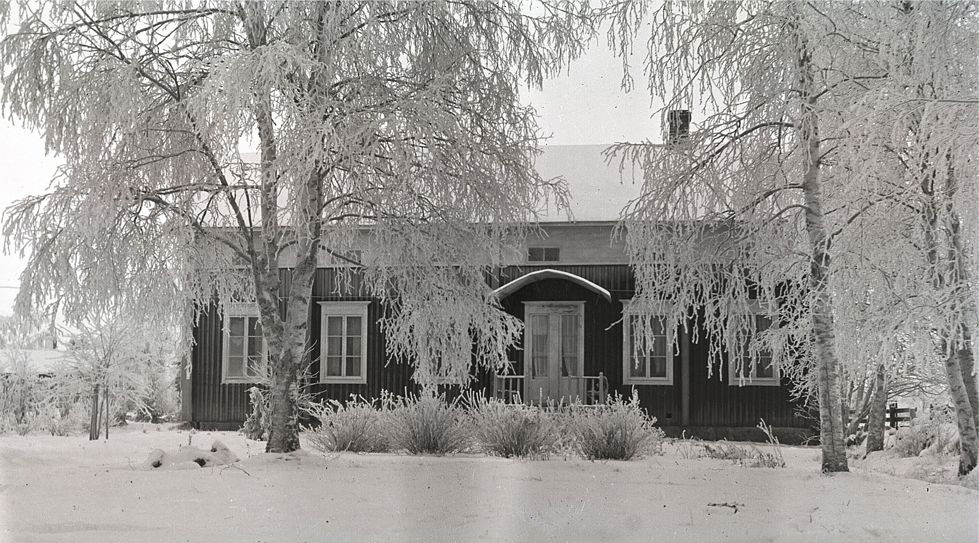 Södra folkskolans lärarbostäder fotograferad från vägen 1928. Läraren Selim Björses bodde i den norra bostaden, alltså till vänster på bilden och lärarinnan bodde i den södra bostaden.