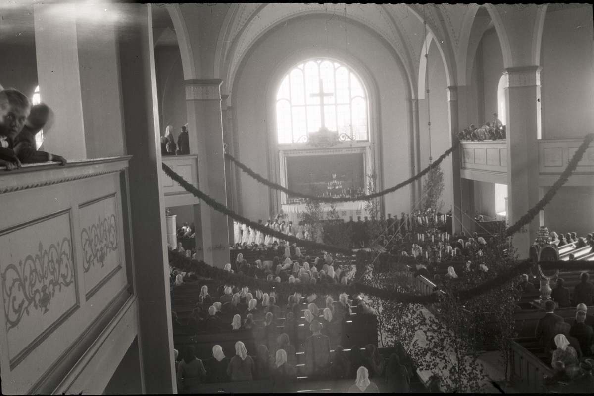 Kyrkan vackert dekorerad med enrisband och björkar.