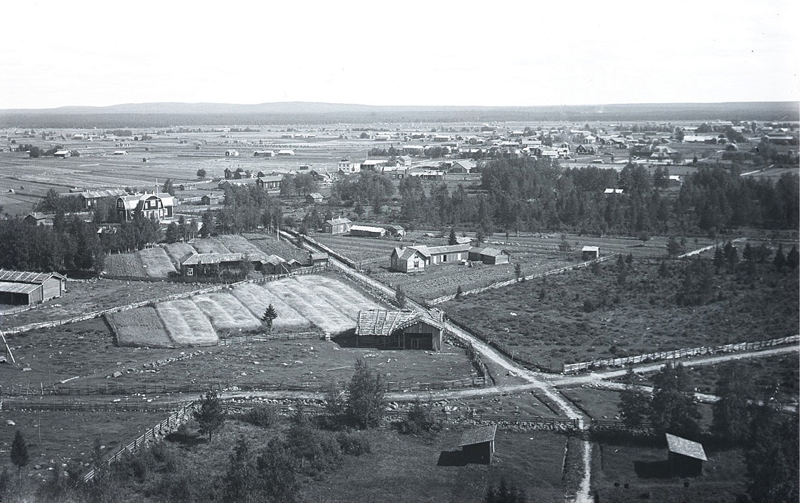 Foto från klockstapeln eller kyrktaket mot nordöst. Kyrktået och den finska folkskolan mitt i bild.