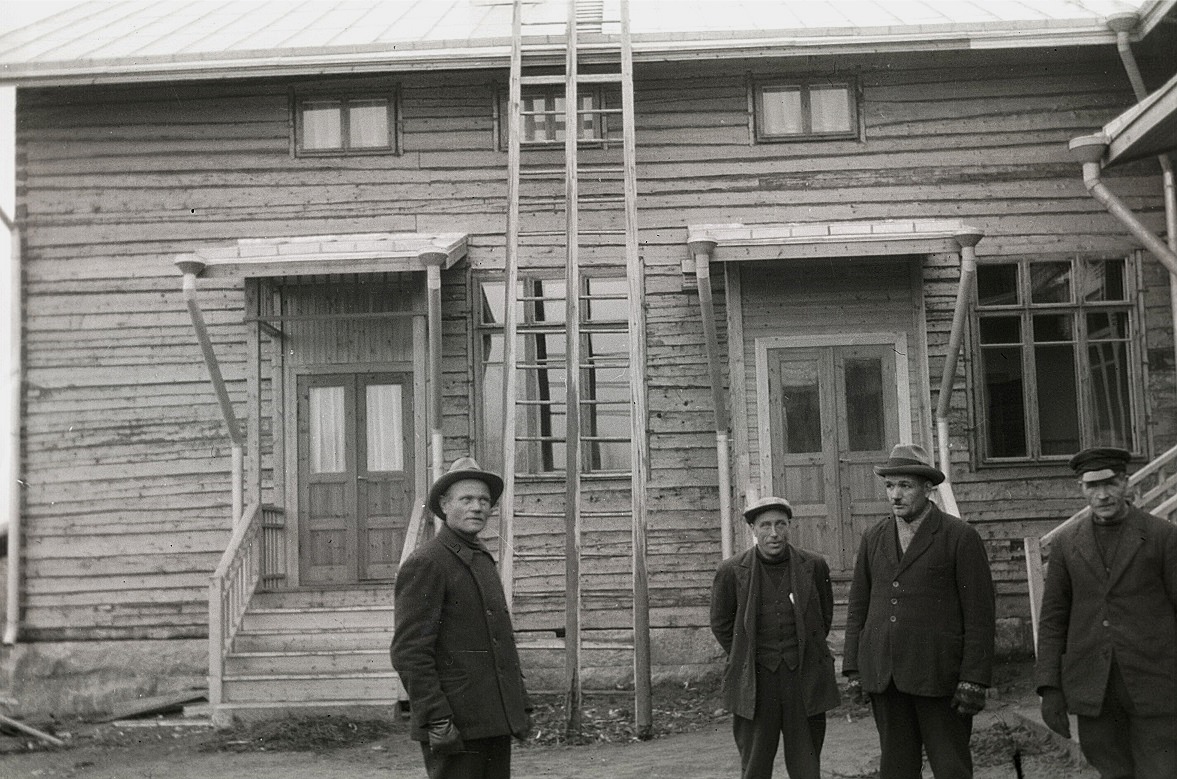 På hösten 1933 är tillbyggnaden färdig. Den vänstra ingången till lärarinnan Tekla Skrivars bostad och genom den högra dörren kom man till tamburen, en skolsal och skolköket. Till vänster står Karl Knus, entreprenören Erland Krook, sedan Emil Ekman och till höger står Viktor Rosenstedt.