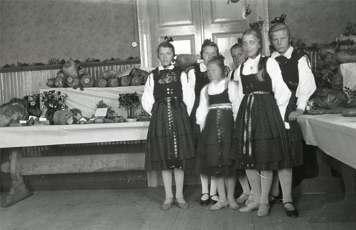 Utställning av lantbruksprodukter i skolan, där flickorna har fina folkdräkter, från vänster Svea Ådjers, Helmi Ekman, Anni Enlund, Agnes Ålgars och Elin Mangs.