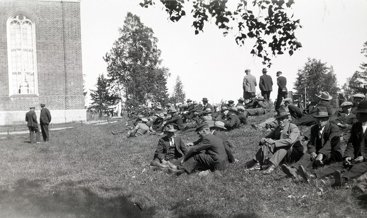 Här sitter gubbarna utanför kyrkan och njuter av sommarvärmen, på midsommardagen 1936.