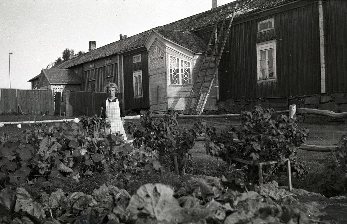 Hildur Ludén från Härkmeri som sedan gifte sig med Sigurd Ekström från Påskmark, här utanför den Byholmska gården. Se vilken gård och vilka verandor!
