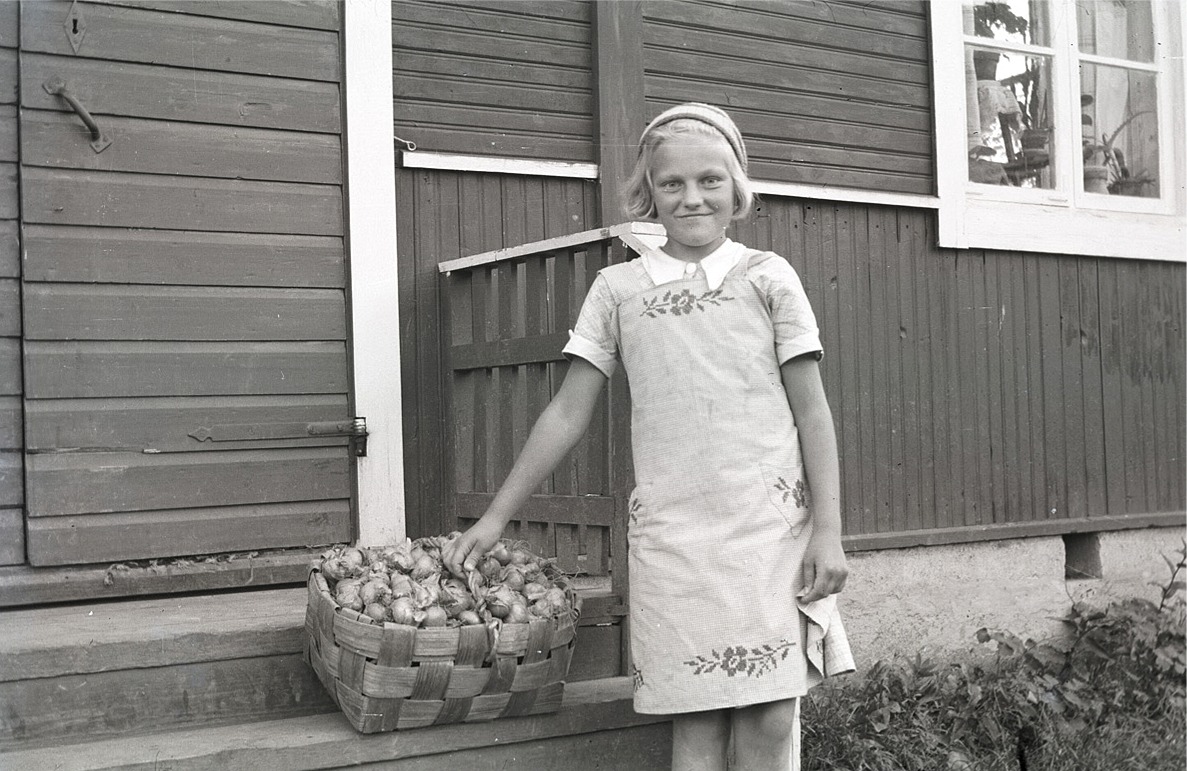 Doris Bergmark, som sedan gifte sig med Gösta Uljens står här och visar upp sin korg med lökar.