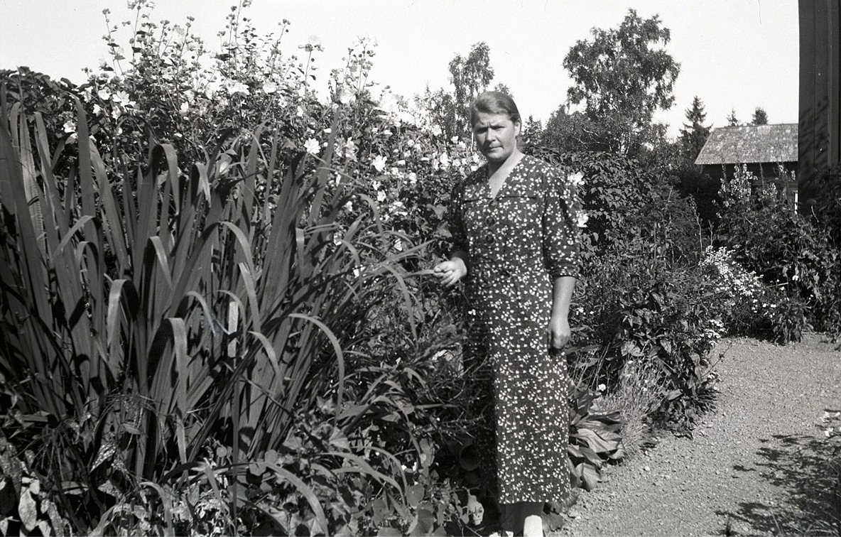 Eufrosyne Björses (1901-1949) var syster till fotografen och folkskolläraren Selim Björses, i vars trädgård hon står på fotot.