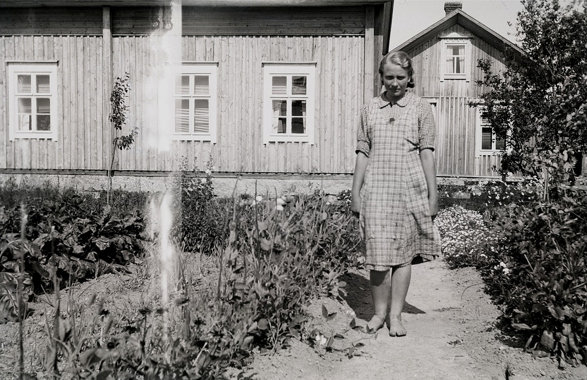 Greta Ebb (f. 1922, senare gift med Yrjö Sillanpää) i sin trädgård framför hemmet.