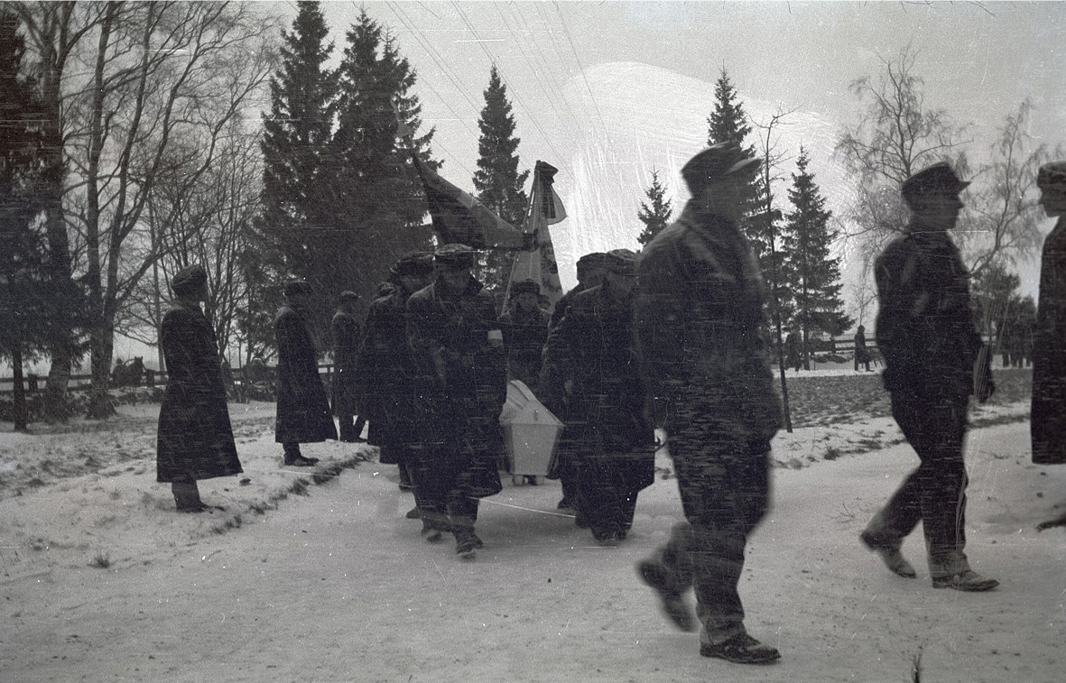 En stupad soldat bärs i snöyran in i kyrkan.