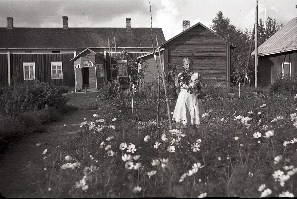 Ingeborg Ålgars visar upp sitt klubbland med föräldrahemmet i bakgrunden. År 1937 gifte hon sig med kantorn Eskil Ericsson och efter hans död gifte hon sig 1959 med Karl Ulfves.