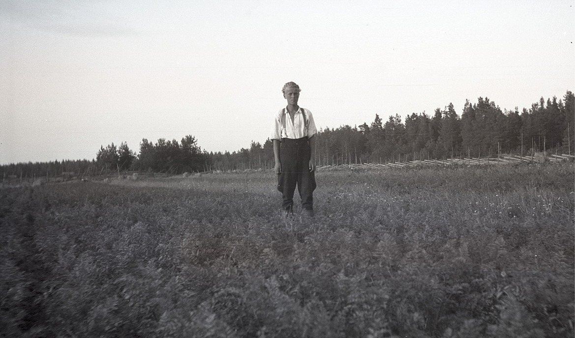 Med tidstypiska påsaböxor och stövlar står Bernt Kronman i sitt morotsland. Notera den fina gärdesgården i bakgrunden.