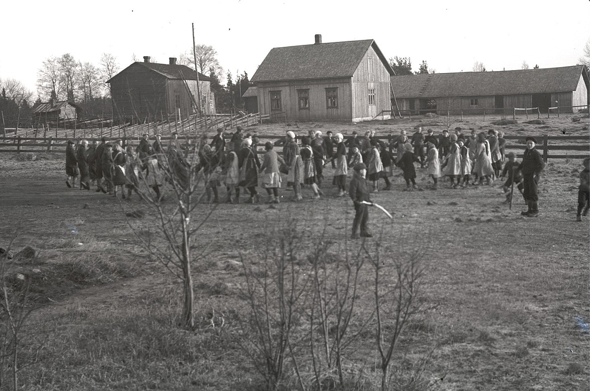 Elevernas ringlekar på skolgården. Mitt i bild "Gustas Kaalas" gård, alltså Artur och Hilma Ådjers gård. Till vänster står Arturs farmor Henrikas gård, där också Arturs faster Manda bodde..