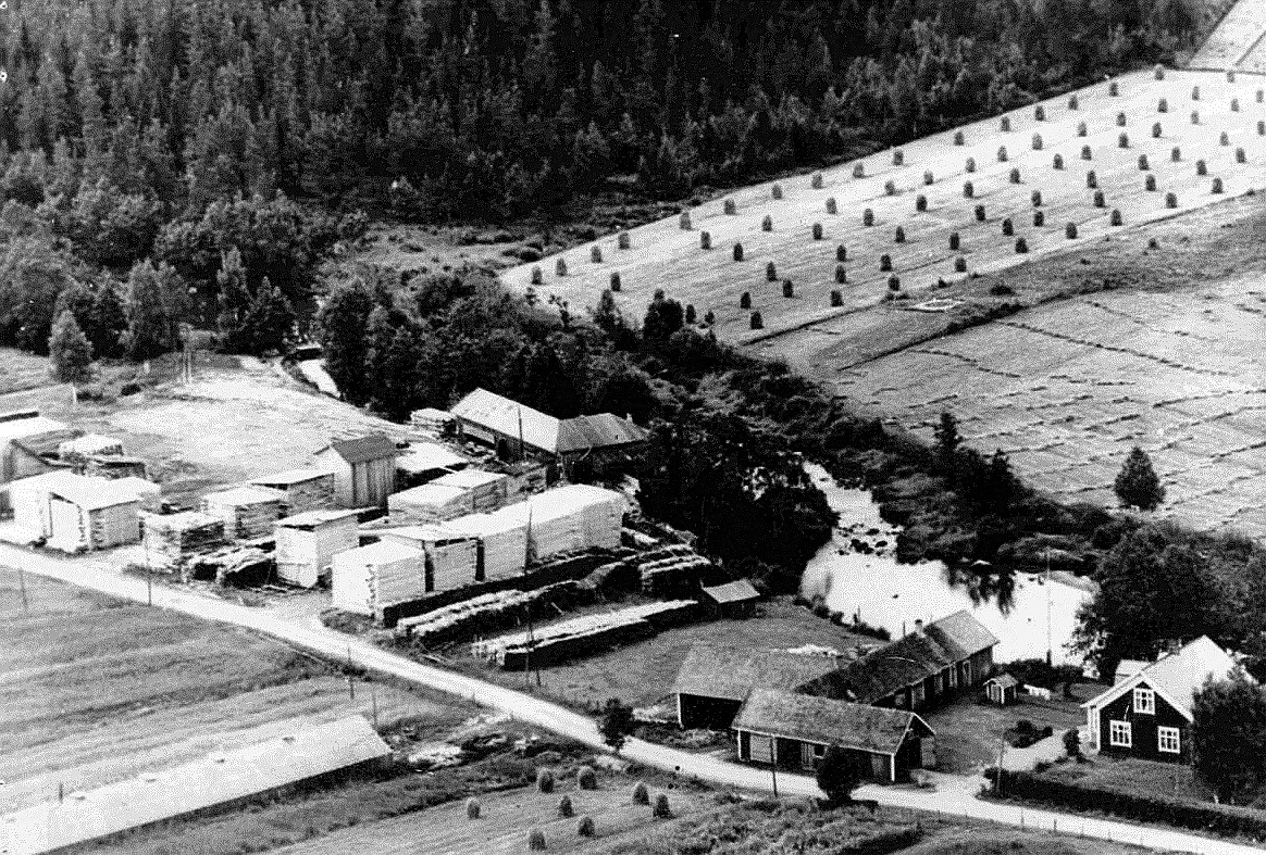Flygfoto från tidigt 60-tal där Kvarnå Såg syns mitt i bild och sågägaren Emil Nyholm gård till höger. Själva sågbyggnaden byggdes i början på 1950-talet, då den gamla från 1930 revs.