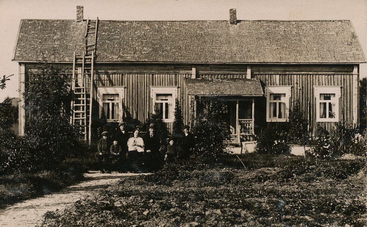 Framför huset sitter Ida och Emil Båsk med sina barn: Einar, Hjalmar, Birger, Thure, Wilhelm och i Idas famn ligger Ethel som var nyfödd då fotot togs år 1922. Efter att familjen flyttat till Kristinestad föddes sonen Filip år 1924 men han drunknade då han var 4 år gammal.