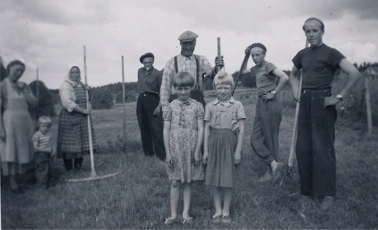 Höbärgningen förr var ett tidsödande arbete som hela familjen deltog i. Till vänster står Gerda Eskola med dottern Eila, Hulda håller i räfsan, Nils tänder sin tobak och Johan Viktor håller i högaffeln liksom sönerna Boris och Rune. Framför Johan Viktor står grannflickorna Inger och Solveig Dahlroos. Fotot från mitten på 1950-talet.