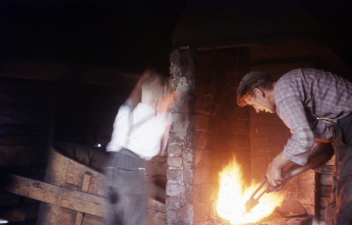 På Nils Bergmans foto håller Otto järnet i ässjan med sonen Sixten hjälper till. 