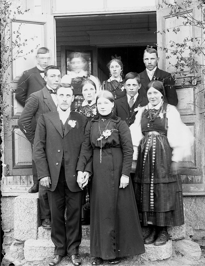 Midsommaren 1916 gifte sig Erik Anders Båsk med Selma Eklund från Brobackan. Längst bak till vänster står Emil Eklund och bredvid honom kanske hans fästmö Hulda, som han skulle gifta sig med i september samma år. Följande är Sandra Forsgård som står bredvid Johannes Gröndahl. I mitten står Frans Eklund bredvid Selma Gröndahl och paret till höger ser ut att vara Frans och Selma Holmudd.