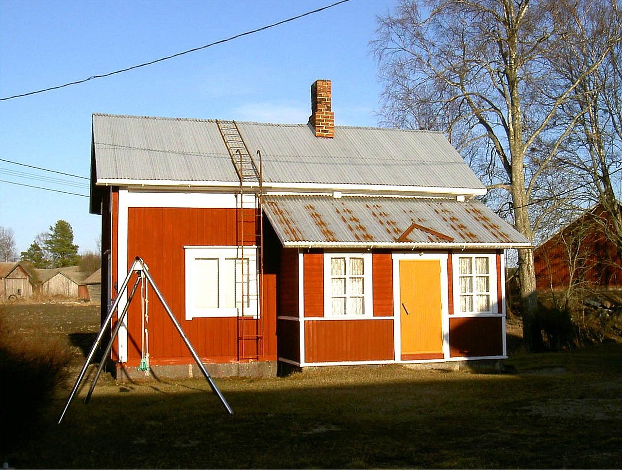 Efter att Hilma Sandlund hade sålt hemmanet åt familjen Norrvik flyttade hon till lillstugan och hon bodde ensam där under en lång tid. Hilma dog år 2000 och hon var den sista som bodde i lillstugan. I vänstra kanten syns hennes barndomshem där ”Skomakas”. Fotot från 2003.