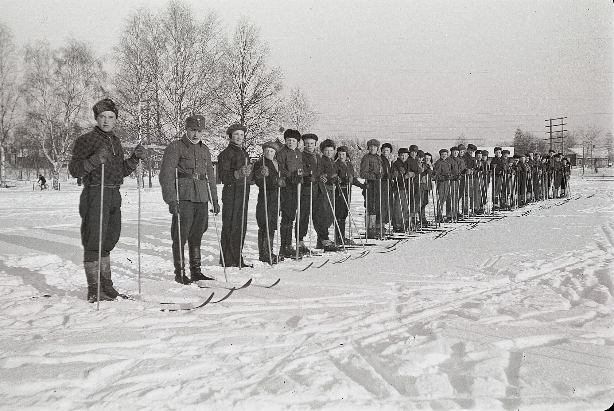 Soldatgossekåren uppställda med skidor på sportplanen. Till vänster Åke Ålgars och Torsten Mitts.