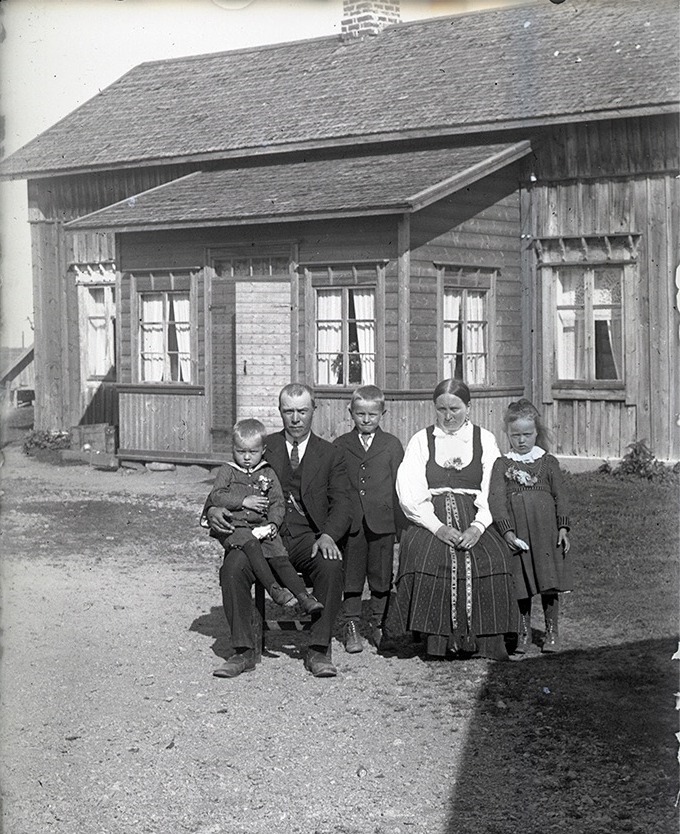 Här sitter skräddaren Viktor Söderqvist (1883-1954) med sonen Yngve (1920-2005) i famnen. Mitt i bild står Valter Söderqvist (1916-2005) bredvid mor Amanda (f. Söderholm 1888-1959). Till höger står Ellen (1918-2010) senare gift Sten. Yngsta dottern Elvi (1926-1968) senare gift Hagback, fattas på bilden.